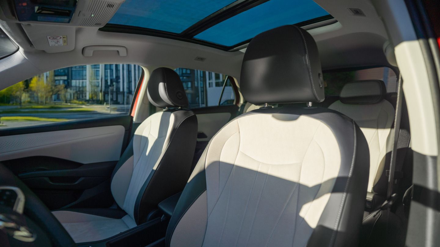 Blick durch die Fahrertür des VW T-Roc Style auf das Interieur mit hellen Sitzen.