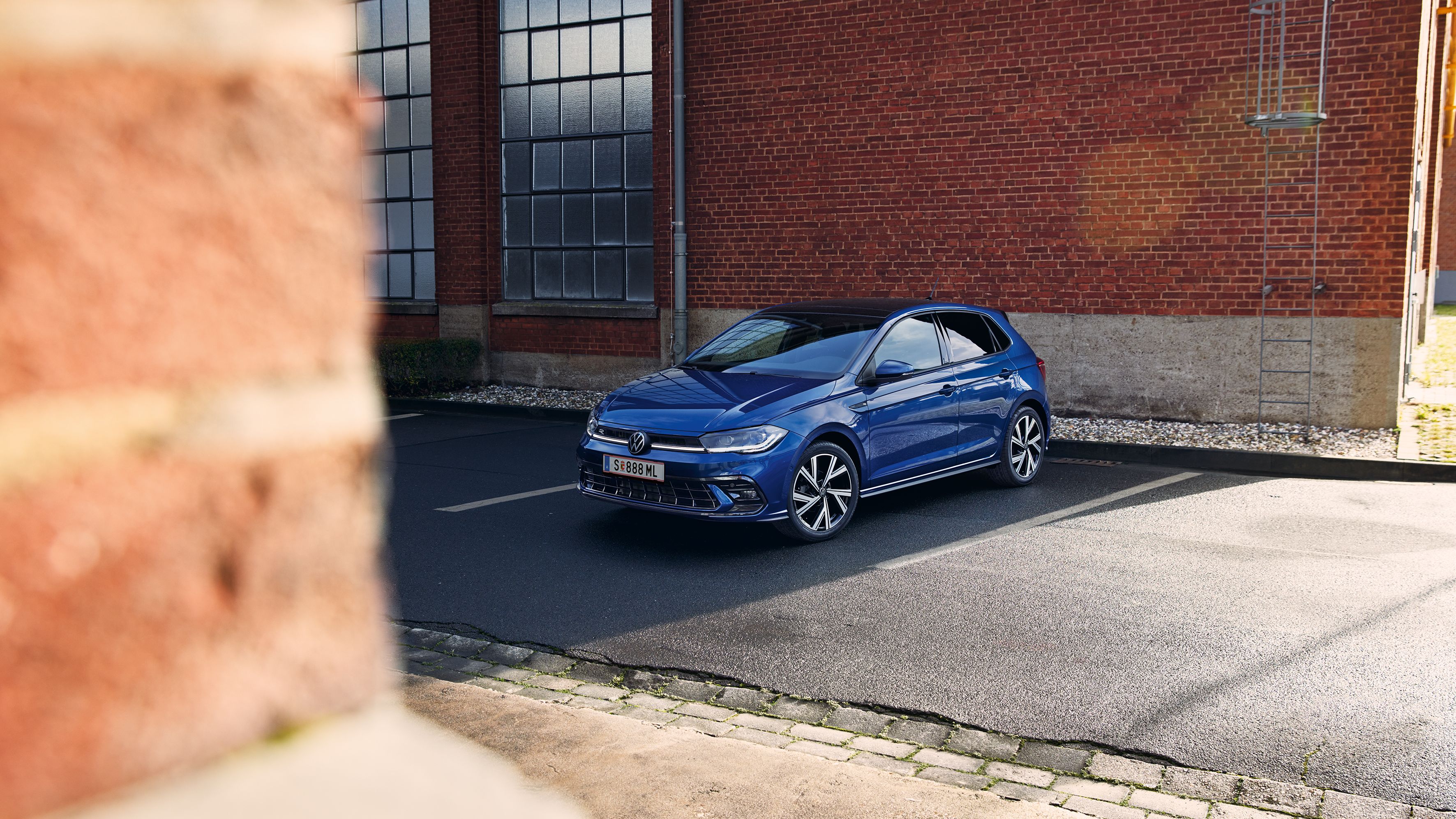 VW blauer Polo parkt vor einem Gebäude
