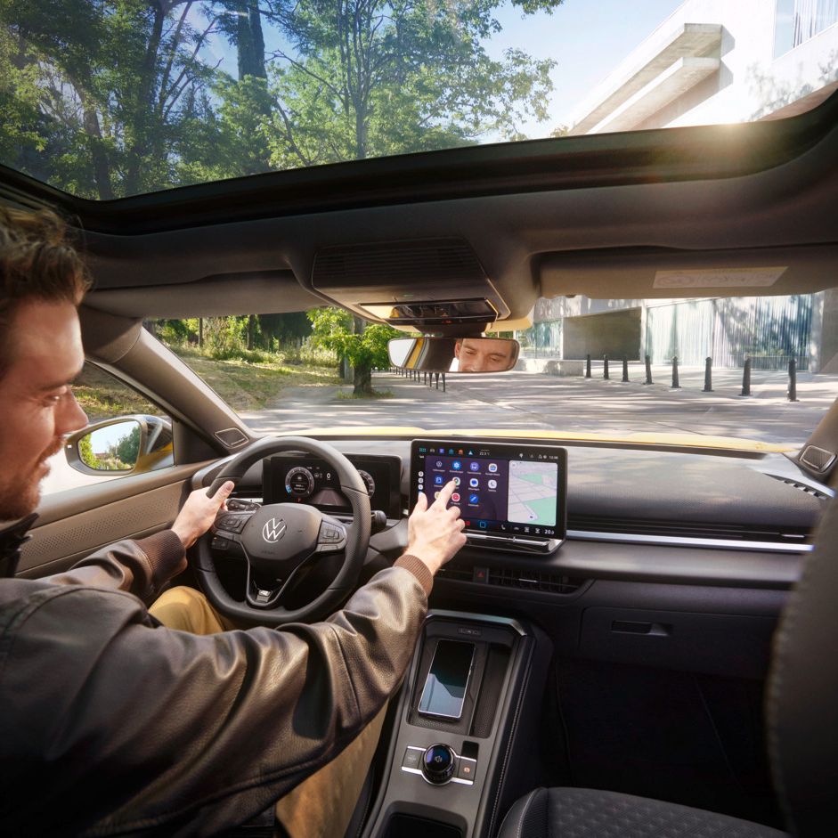 Ein Mann bedient auf dem Infotainment-Display in seinem Volkswagen T-Roc Android Auto über die App-Connect Schnittstelle.