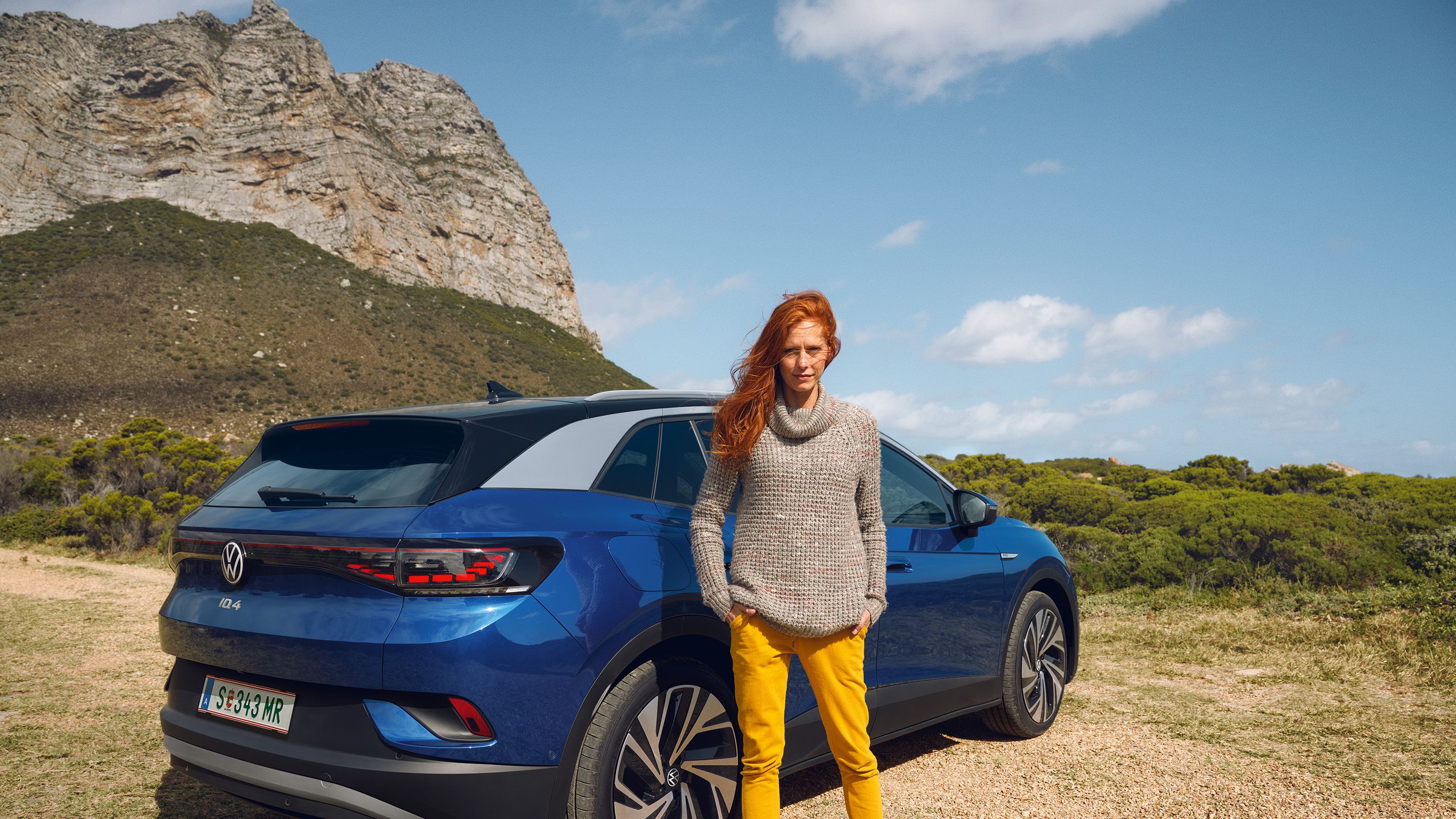 VW ID.4 e verdhë është parkuar para ndërtesës dhe po karikohet