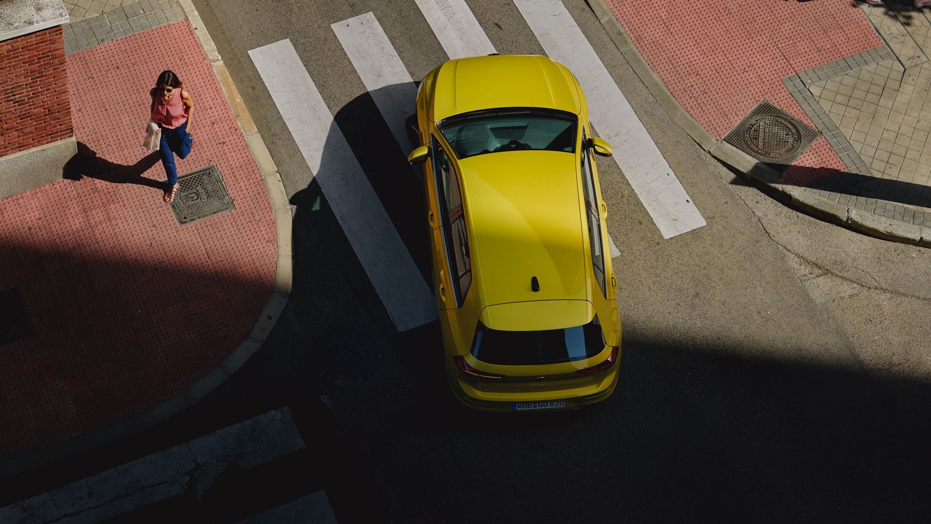 VW Golf që lëviz përreth një kthese, shihet nga perspektiva e syrit të zogut