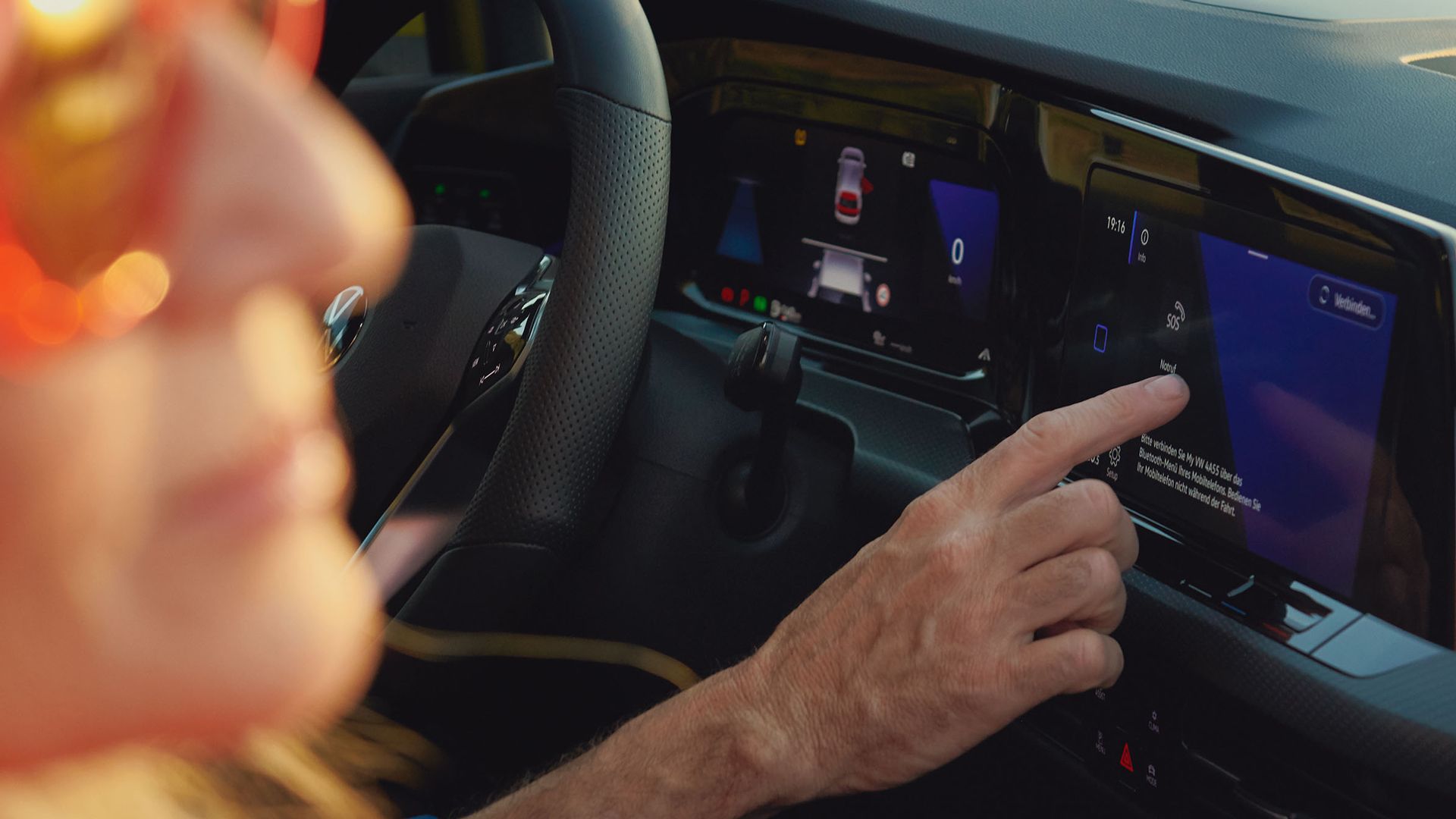 Një burrë ulet në sediljen e shoferit të VW Golf dhe shikon Discover Pro