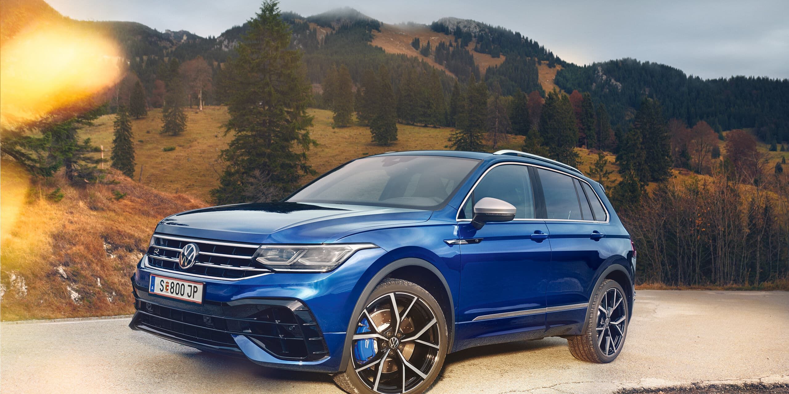 VW SUV Tiguan R in blau seitlich vor Berglandschaft