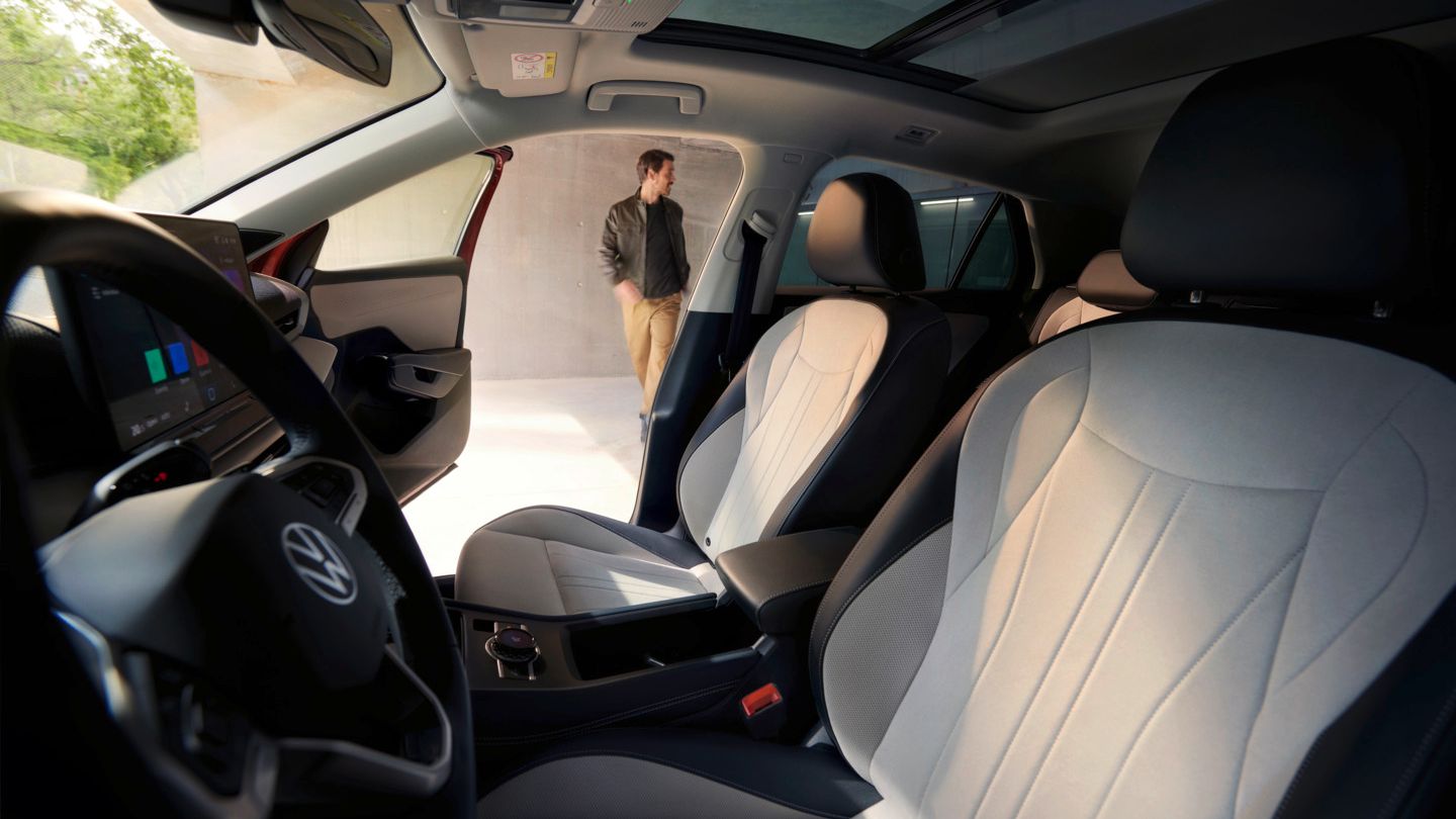 Blick durch die Fahrertür des VW T-Roc Style auf das Interieur mit hellen Sitzen.