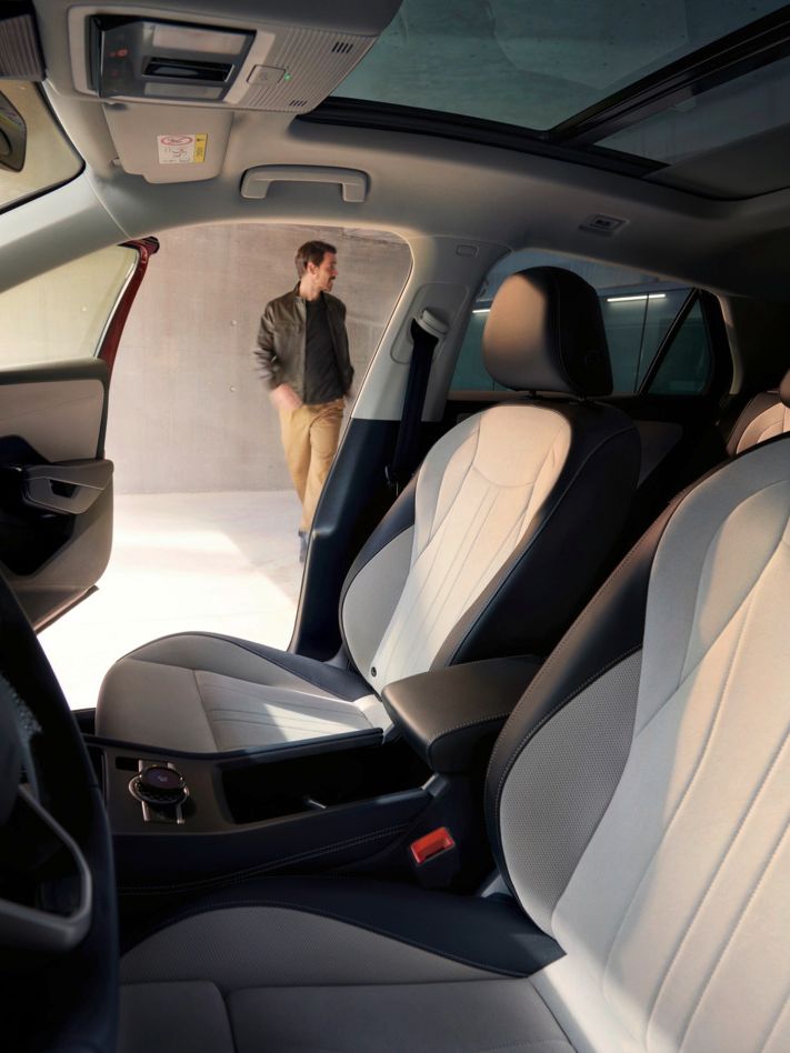 Blick durch die Fahrertür des VW T-Roc Style auf das Interieur mit hellen Sitzen.