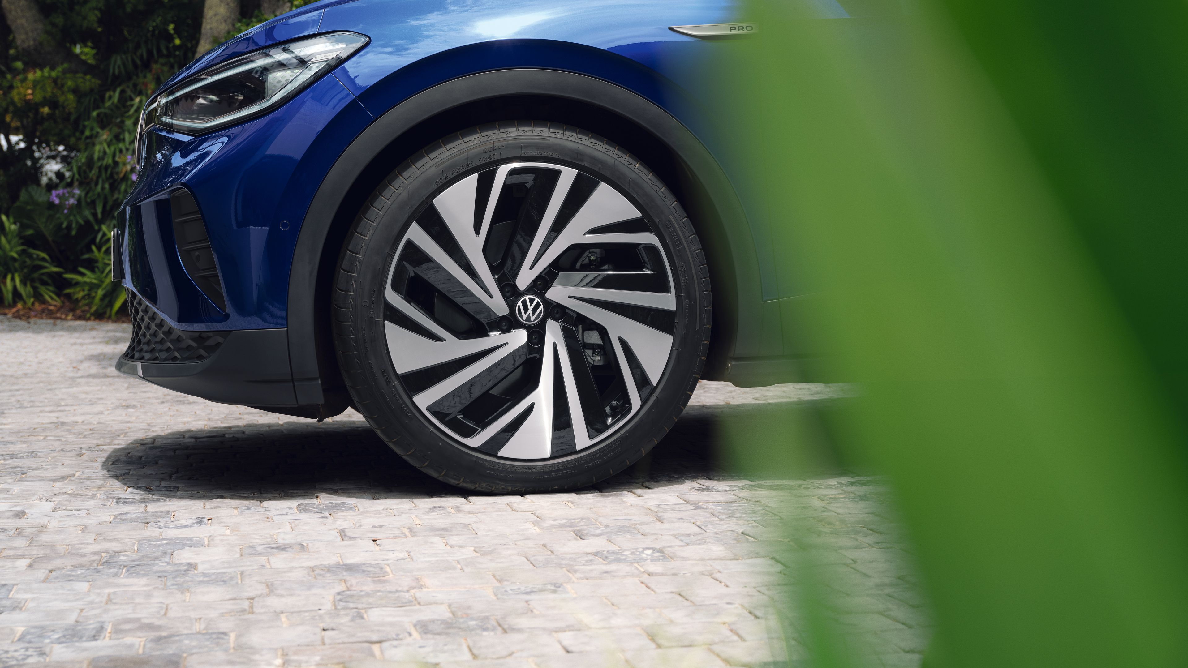 VW ID.4 e verdhë qëndron përpara pyllit dhe liqenit