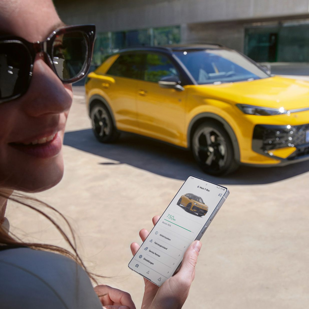 Eine Frau nutzt die App VW Connect nahe ihres VW T-Roc R-Line.