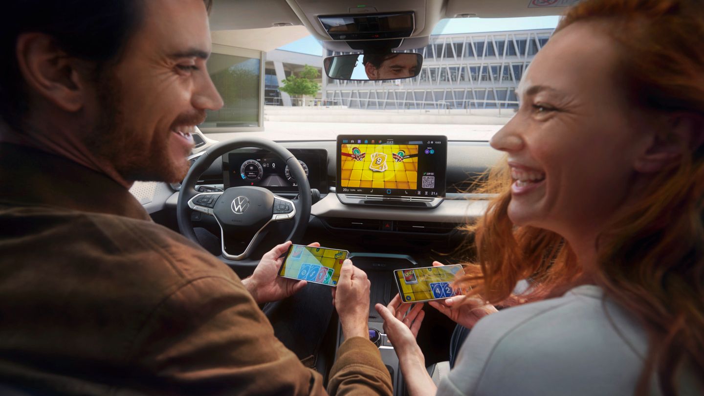 Ein Paar im VW T-Roc Style spielt Uno via AirConsole mit Smartphones als Controller..