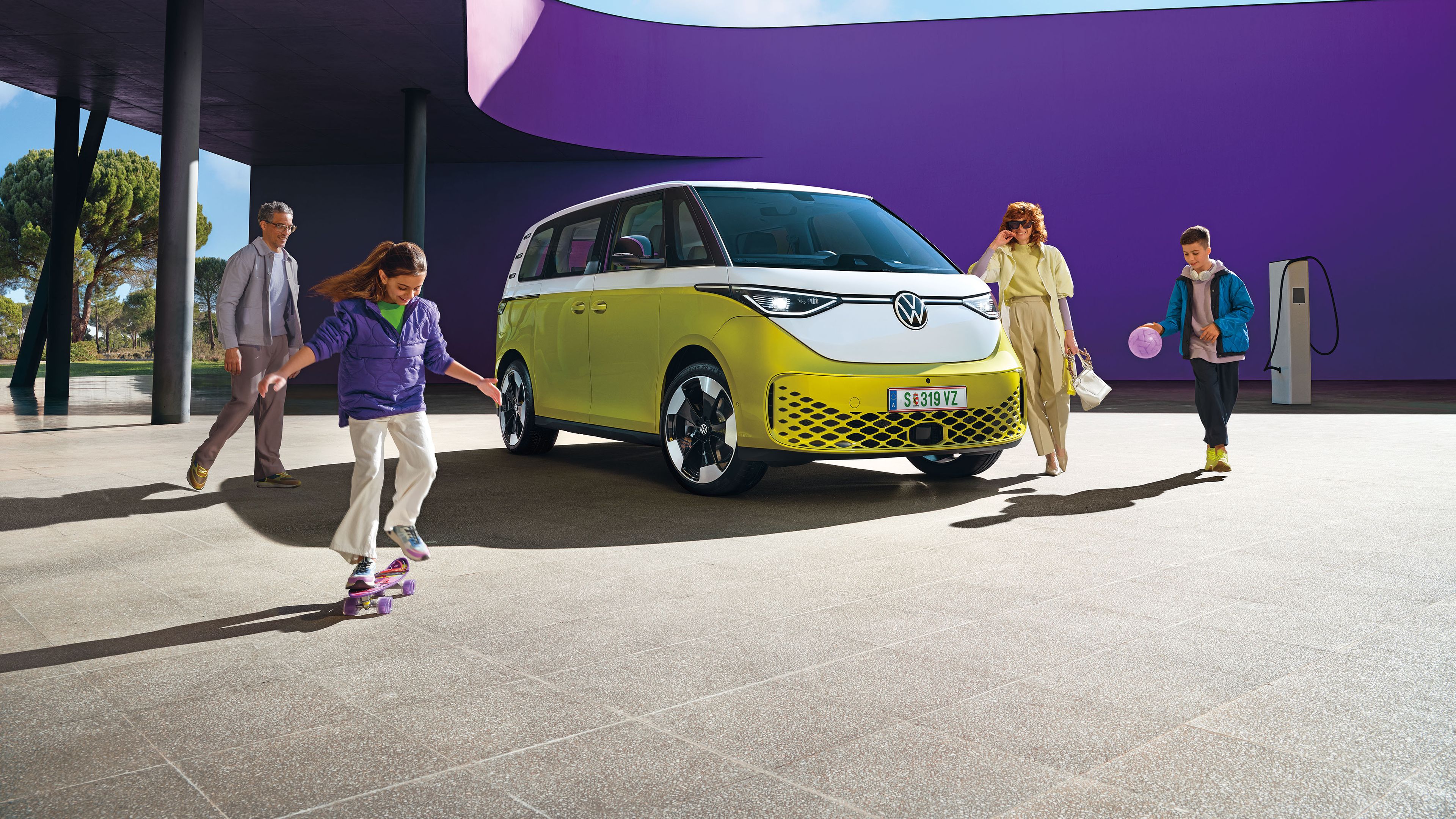 VW ID. Buzz geparkt, Familie tummelt sich um ihn.